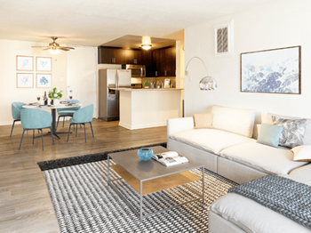 A living room with a white couch and a glass coffee table.
